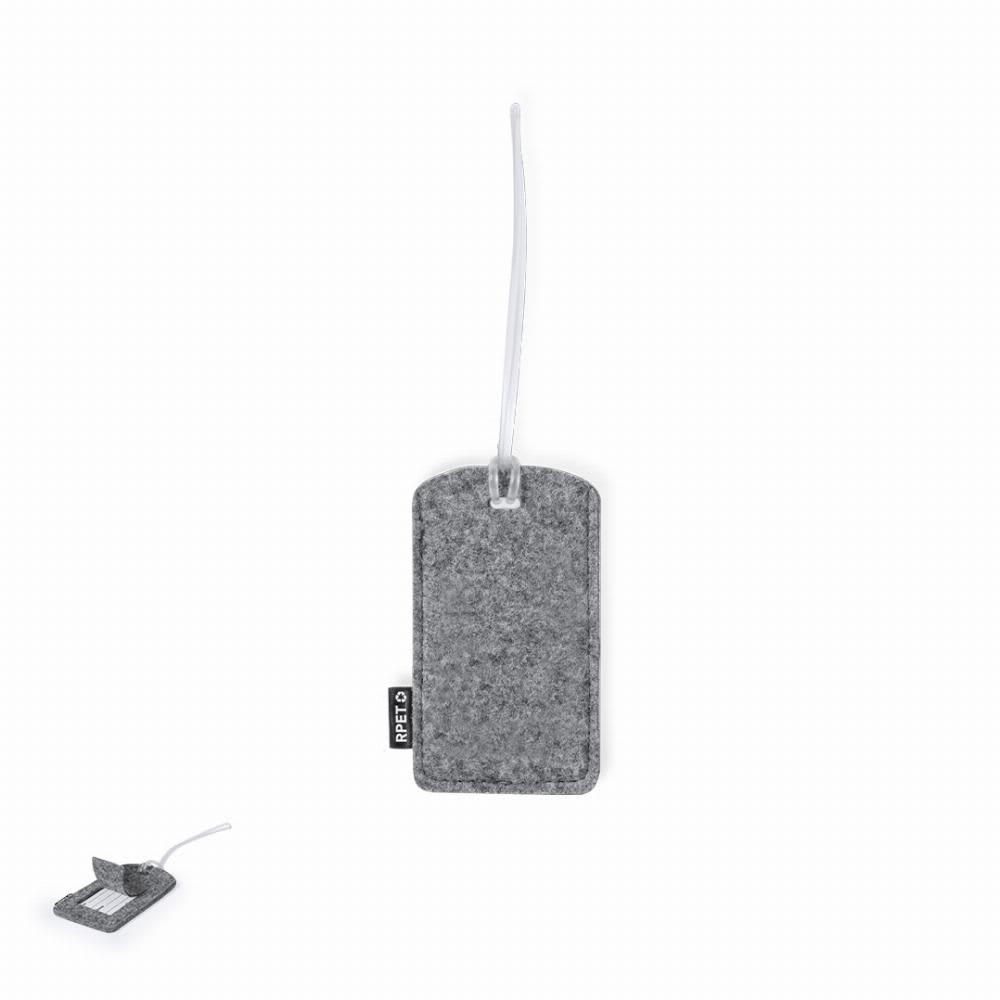 A grey felt luggage tag with a clear loop for attachment, featuring a brand logo. Filip - Image 1