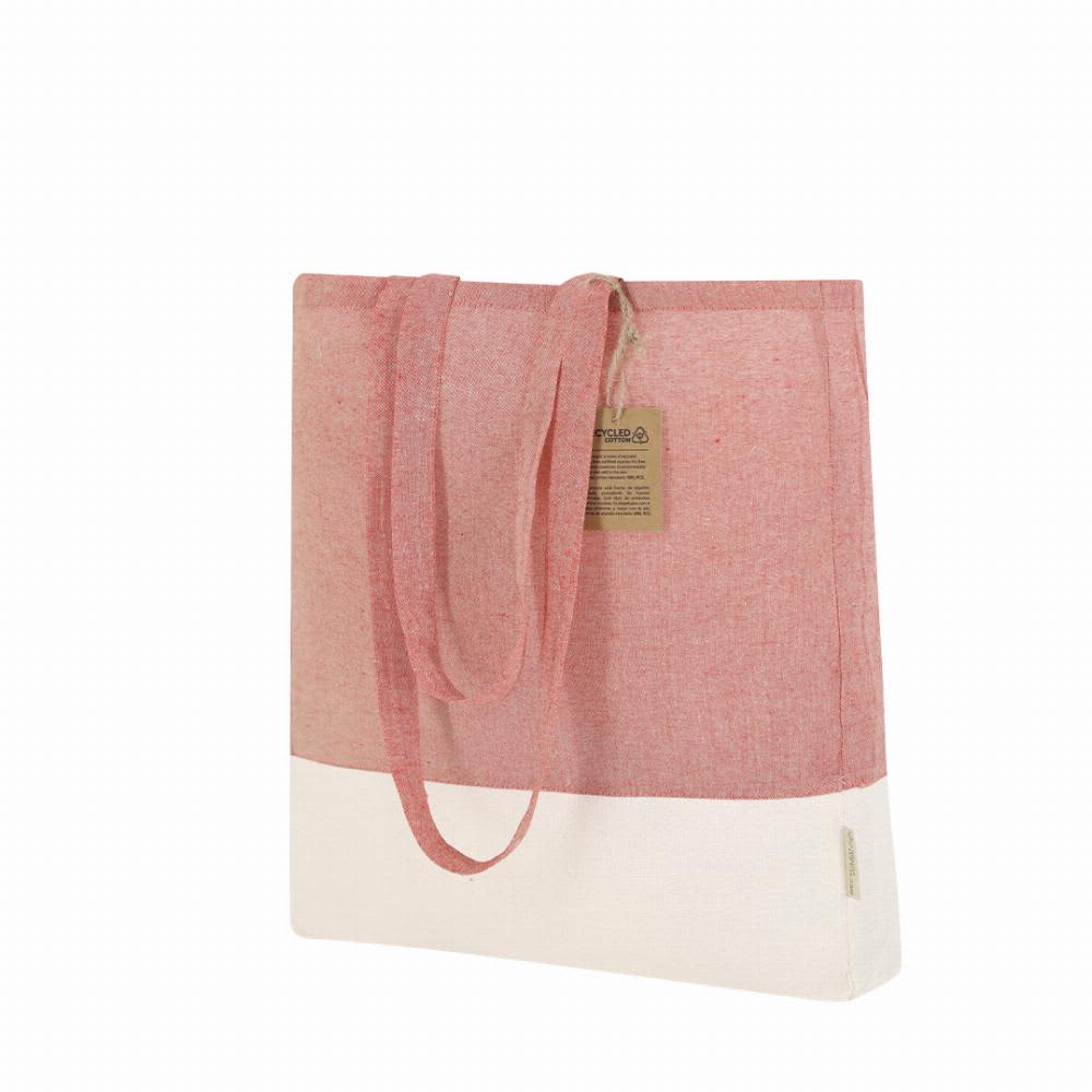 A tote bag featuring a pink and white design with a textured fabric and long handles. It has a branding label attached. Kauna - Image 1