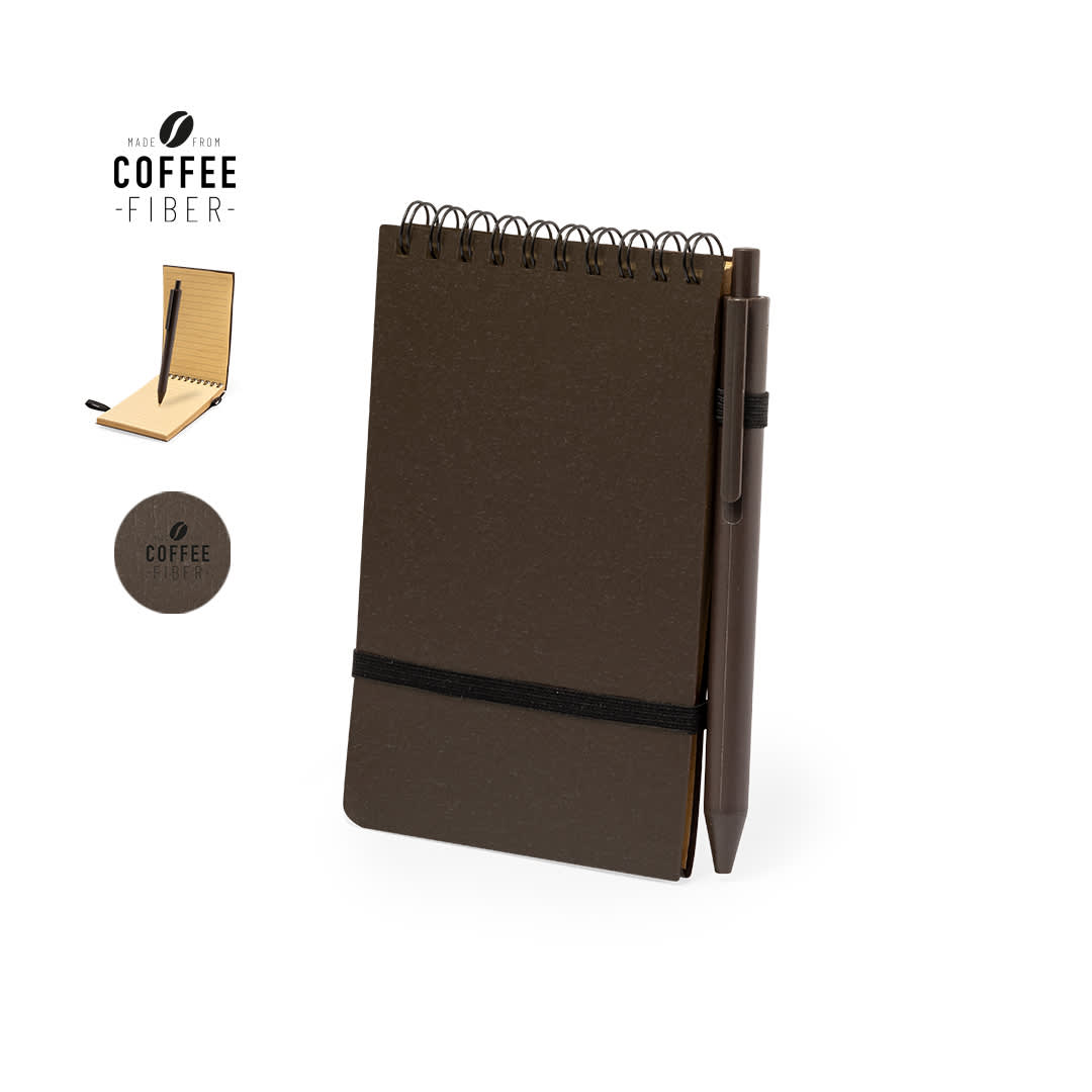 A dark brown notebook with a spiral binding, an elastic band, and a pen attached. There is a logo on the cover. Pacam Notebook - Image 1