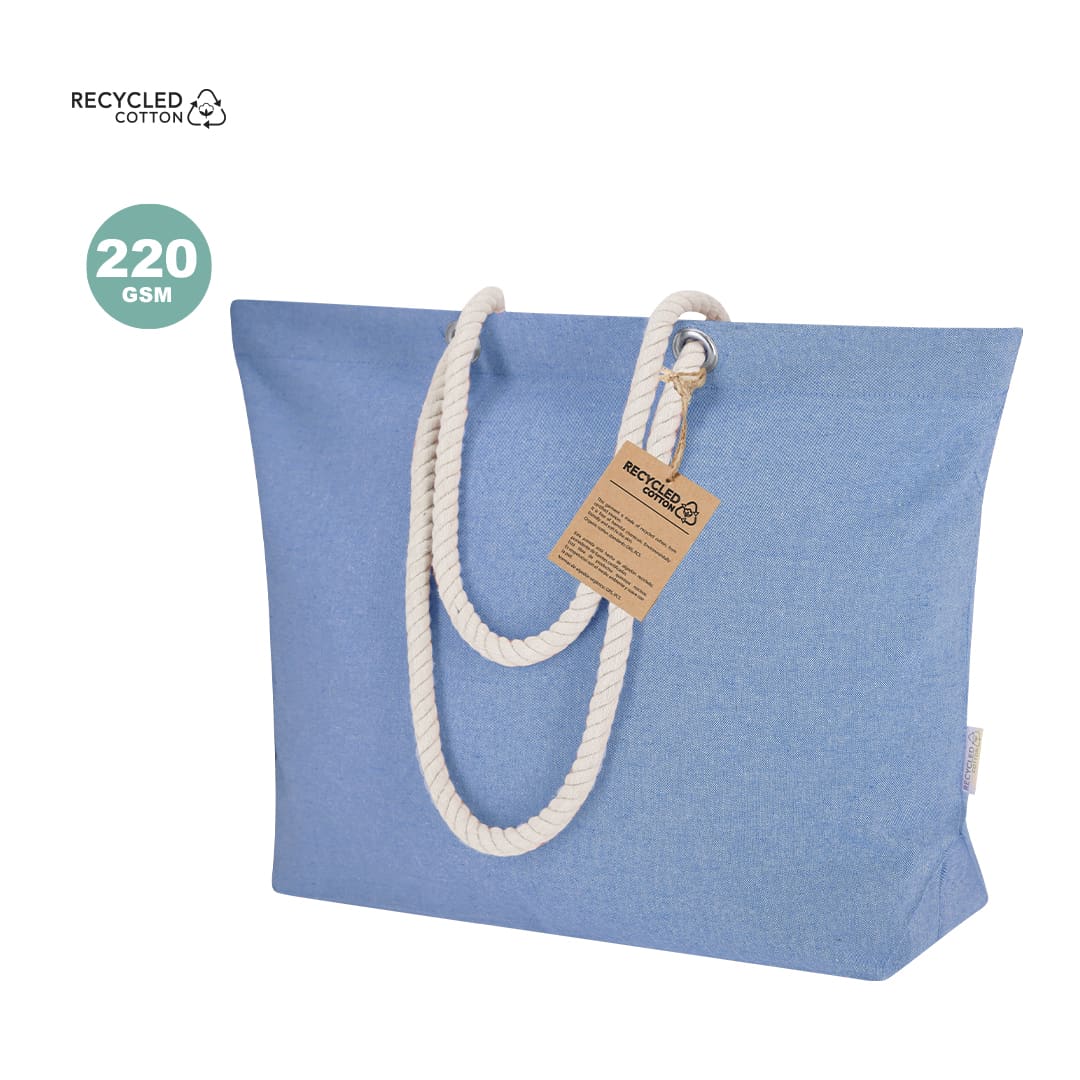 A blue tote bag made from recycled cotton with white rope handles and a tag attached. Coulan Bag - Image 1