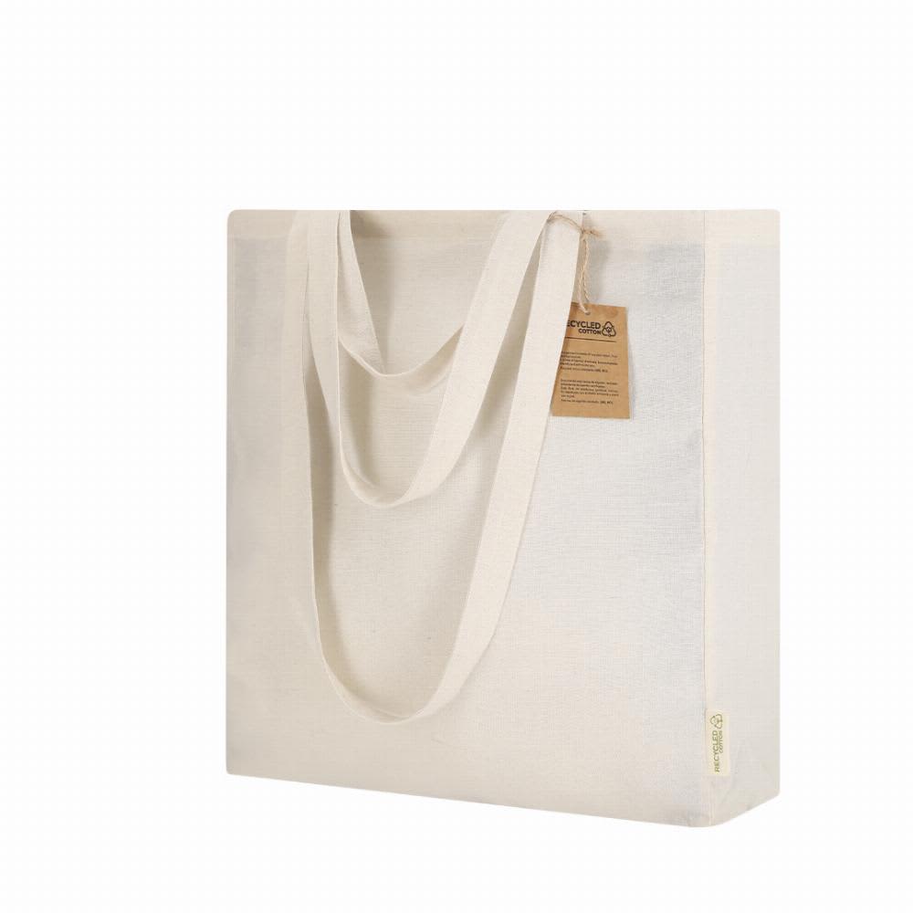 A reusable tote bag in cream colour with two sturdy handles and a tag attached. Features branding on the side. Kamuy - Image 1