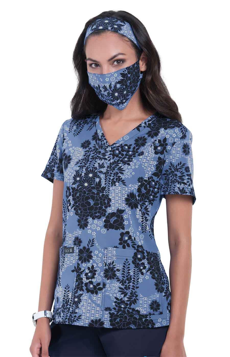 A floral print top in blue with matching face mask and headband, featuring a v-neck and pockets. Leslie Top (Print) - Image 1