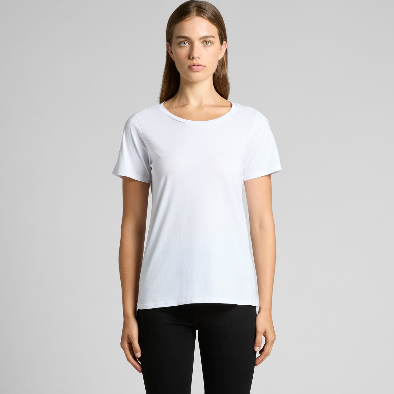 A white t-shirt is displayed on a model, featuring short sleeves and a relaxed fit, with a subtle logo present. Wo's Shallow Scoop Tee - Image 1
