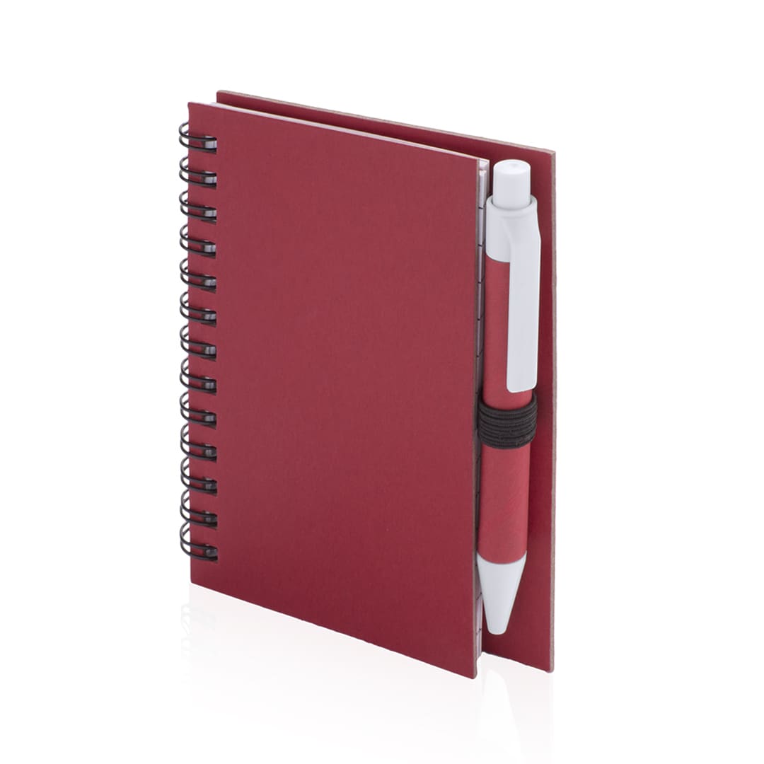 A red spiral-bound notebook with a pen secured on the side. It has a smooth cover and a compact design. Pilaf Notebook - Image 1