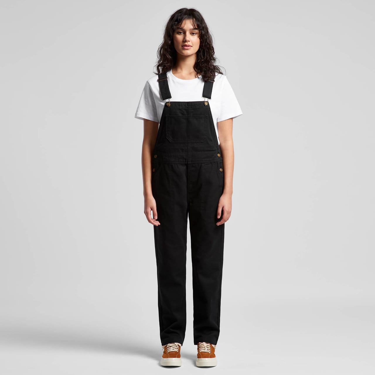 A pair of black canvas overalls worn by a model, paired with a white t-shirt and brown shoes. Wo's Canvas Overalls - Image 1