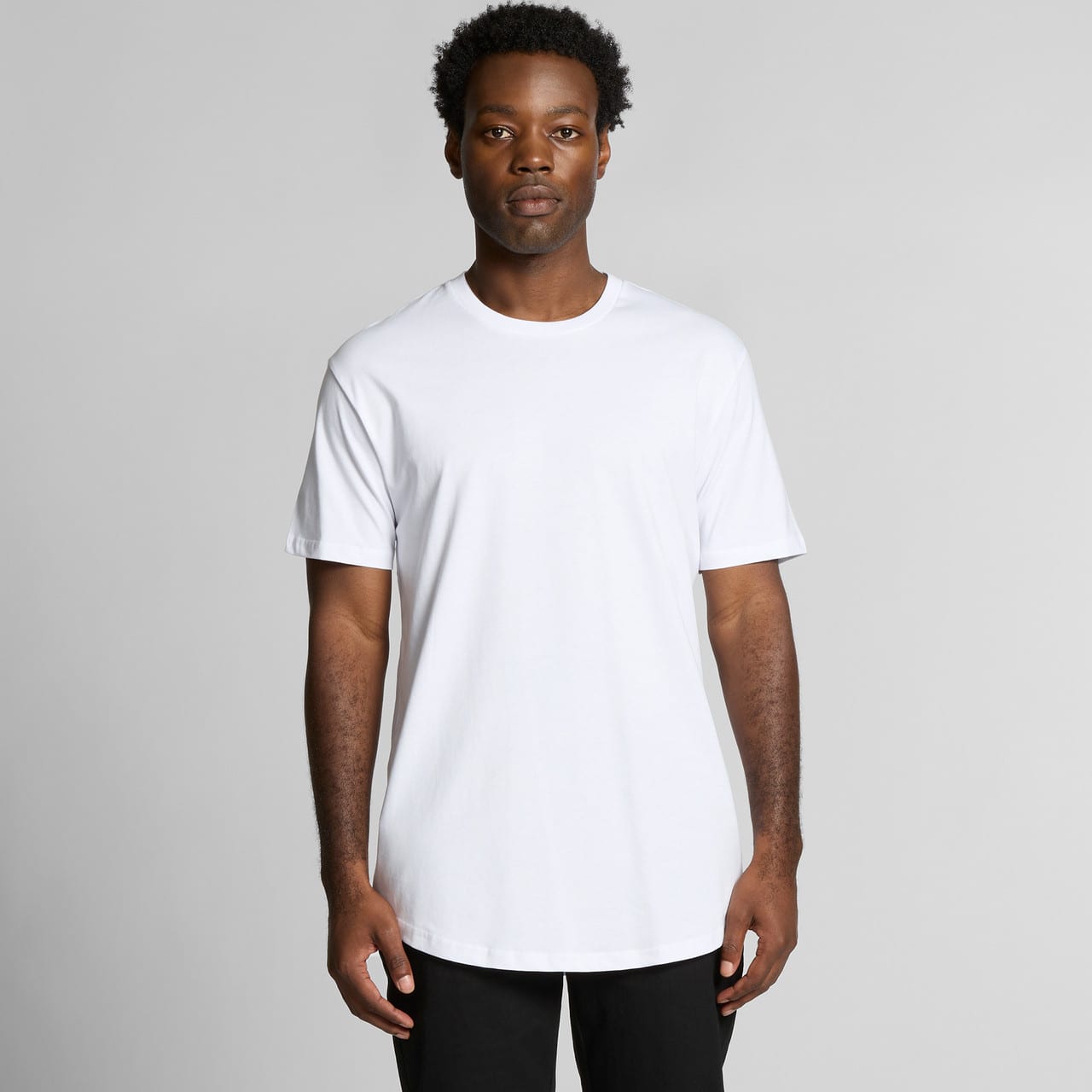 A plain white T-shirt with a relaxed fit, featuring short sleeves and a rounded neckline. It has a logo on it. Staple Curve Tee - Image 1