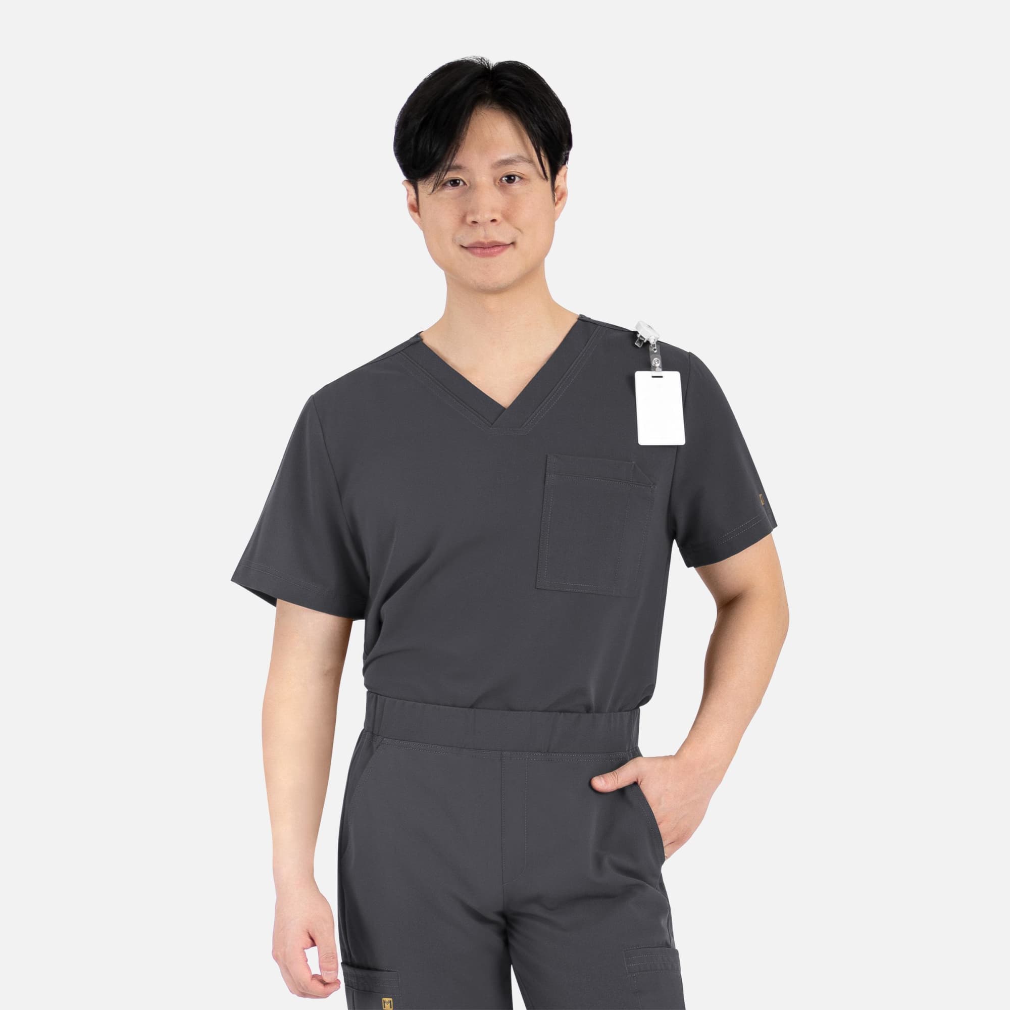 A plain grey men's V-neck top featuring short sleeves and a chest pocket, with a tag attached. Matrix Pro Mens Contrast Piping Tuck V-Neck Top - Image 1