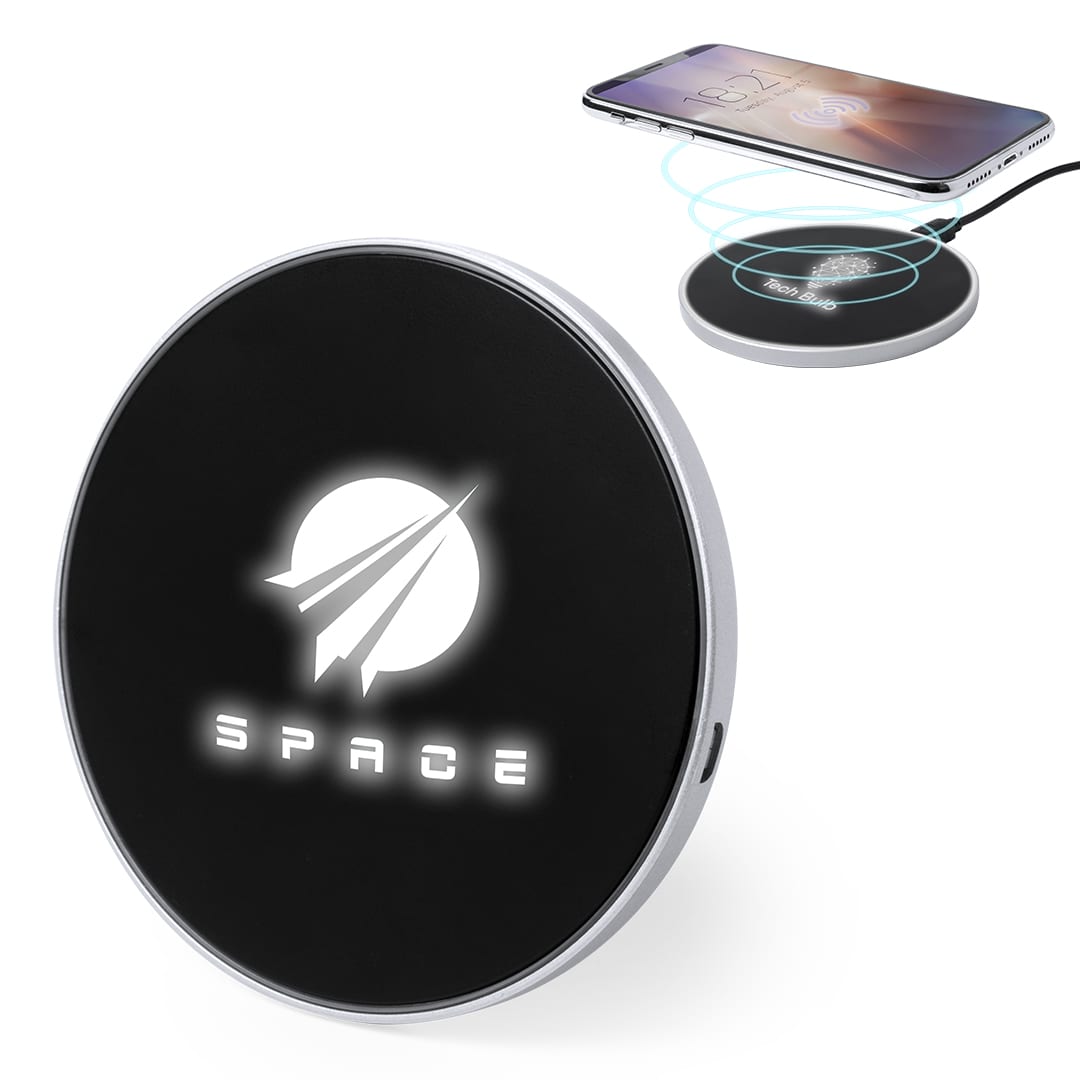 A circular black wireless charger with a silver border and a logo, placed beside a charging smartphone. Brizem Charger - Image 1