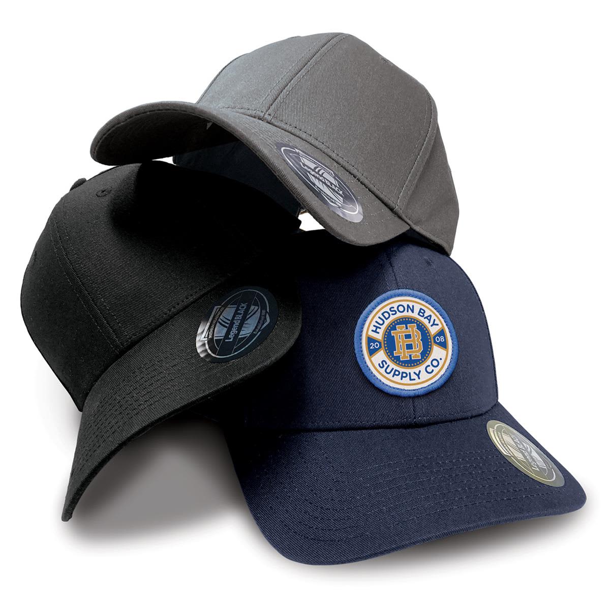 Three caps in grey, black, and navy, featuring a logo on the front, stacked together on a white background. Staple Cap - Image 1