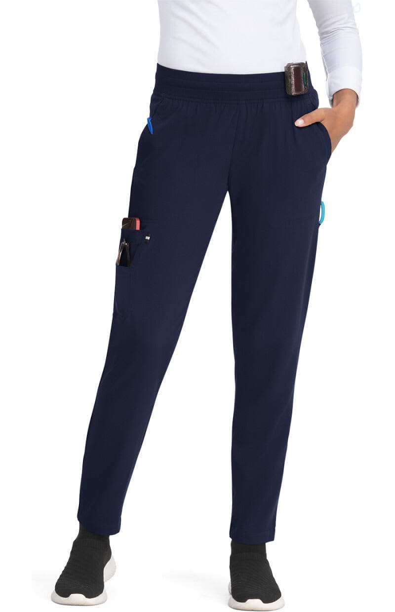 A pair of navy joggers with pockets, featuring a fitted design and elastic waistband. The model is wearing them with a white top. Smart Daily Jogger - Image 1