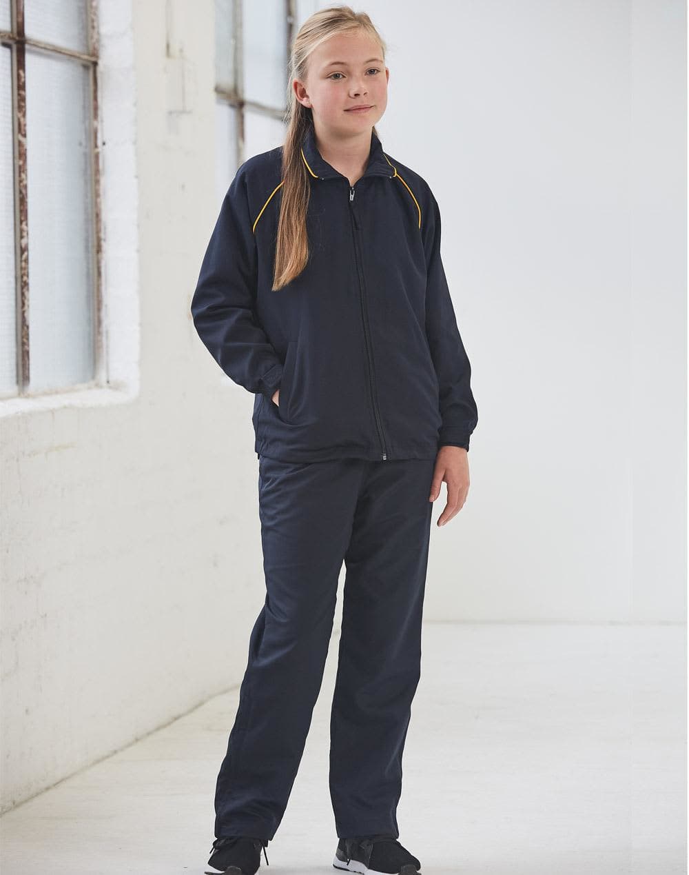 A navy track jacket featuring yellow accents, styled for kids, paired with matching trousers. Kids' track top - Image 1