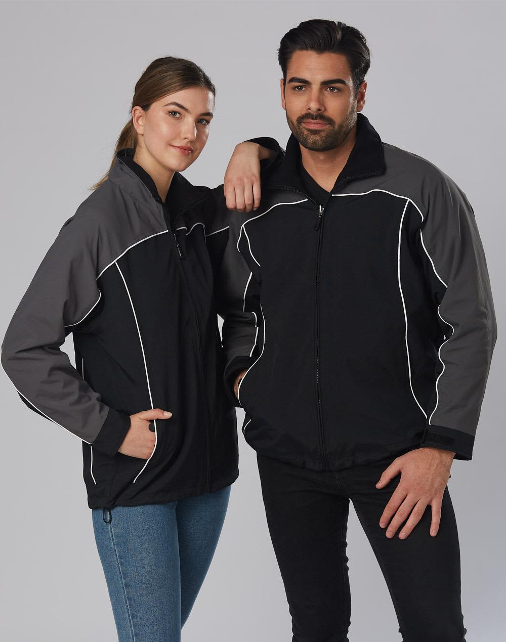 A black and grey reversible jacket featuring a logo, modelled by a man and a woman. Reversible jacket contrast colors - Image 1