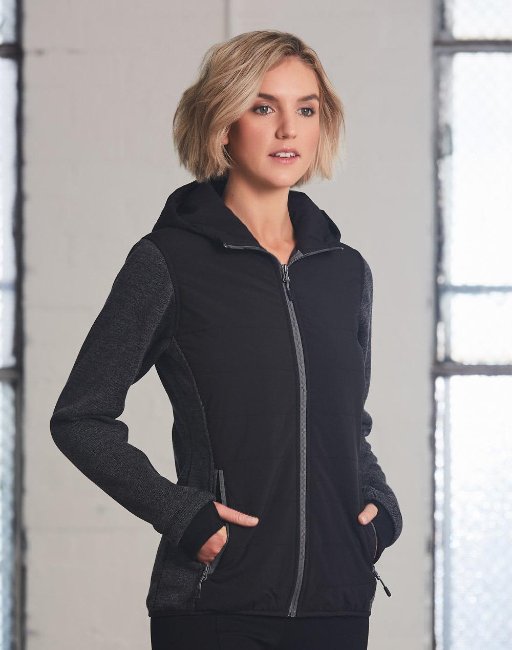 A black and grey ladies' jacket with a hood and zip closure, featuring side pockets and a logo. Ladies' Heather Sleeve/Quilted Body Jacket - Image 1