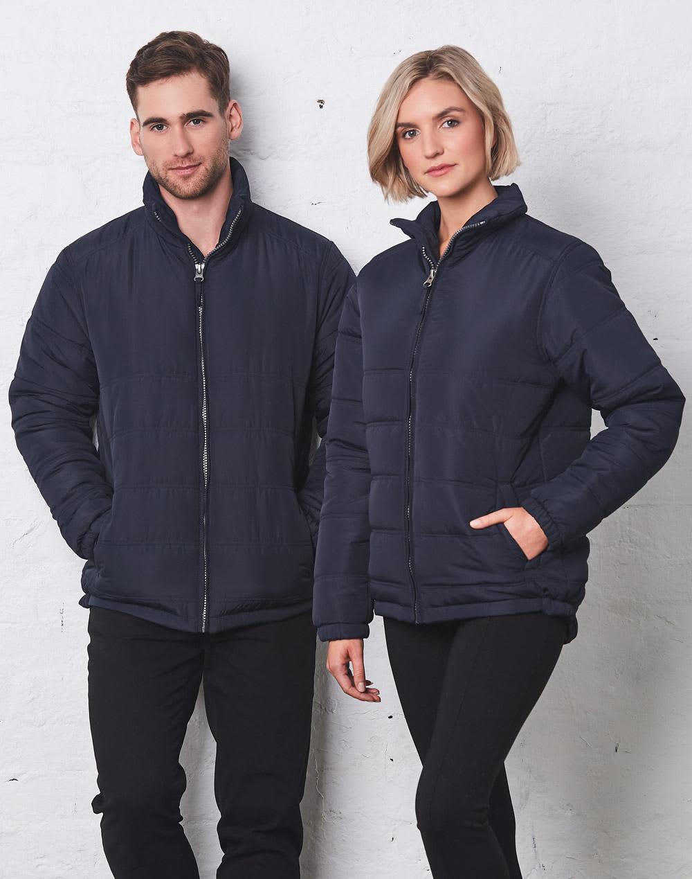 A navy puffer jacket is worn by a man and woman, standing side by side against a light backdrop. Adult's Heavy Quilted Jacket - Image 1