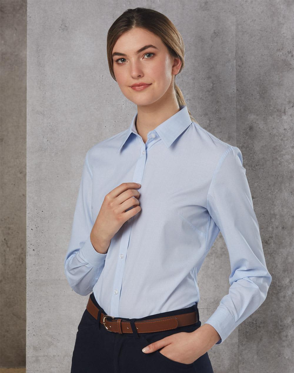 A long sleeve button-up shirt in light blue, featuring a collar and a fitted design, paired with a brown belt. Women's Fine Stripe Long Sleeve Shirt - Image 1