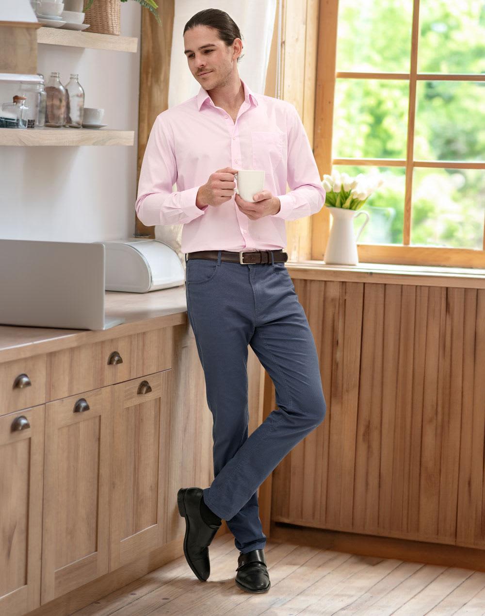 Men's flexi chino pants in navy blue, paired with a light pink shirt, standing in a kitchen setting. Men's Jean Style Flexi Chino Pants - Image 1
