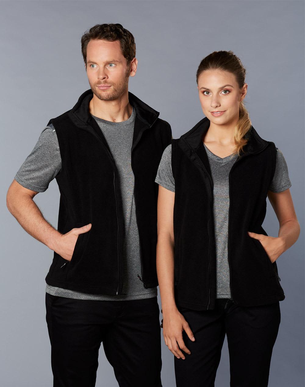 A black polar fleece vest for adults, featuring a zip-up front and side pockets, shown on a man and a woman. Adult's Polar Fleece Vest - Image 1