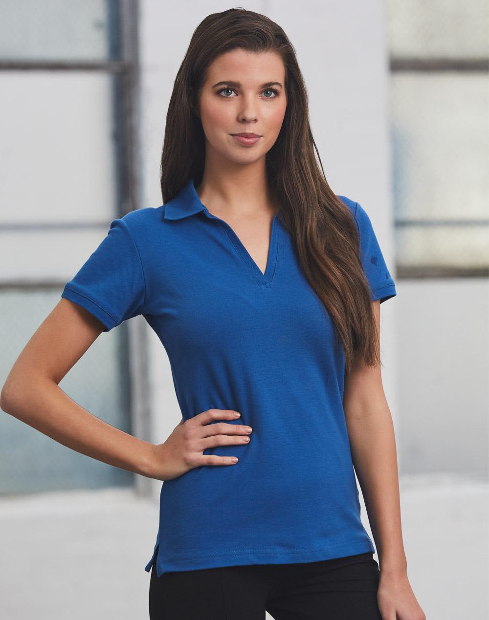 A model wearing a blue Ladies' Longbeach Polo shirt with a collar, featuring a logo. ladies S/S pique polo - Image 1