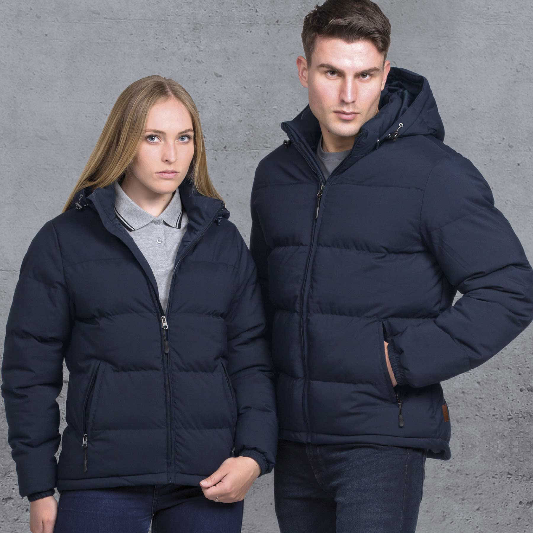 Two models wear navy blue smpli Terrain Puffa Jackets, showcasing a sleek design with hoods and zippers. smpli Terrain Puffa Jacket - Image 1