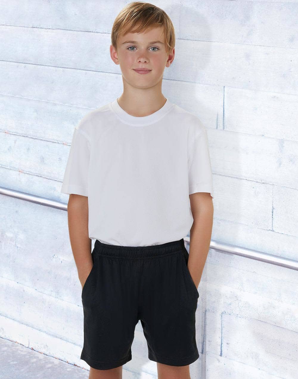 Kids' bamboo charcoal sports shorts in black, styled with a plain white t-shirt, featuring pockets. Kids' Bamboo Charcoal Sports Shorts - Image 1