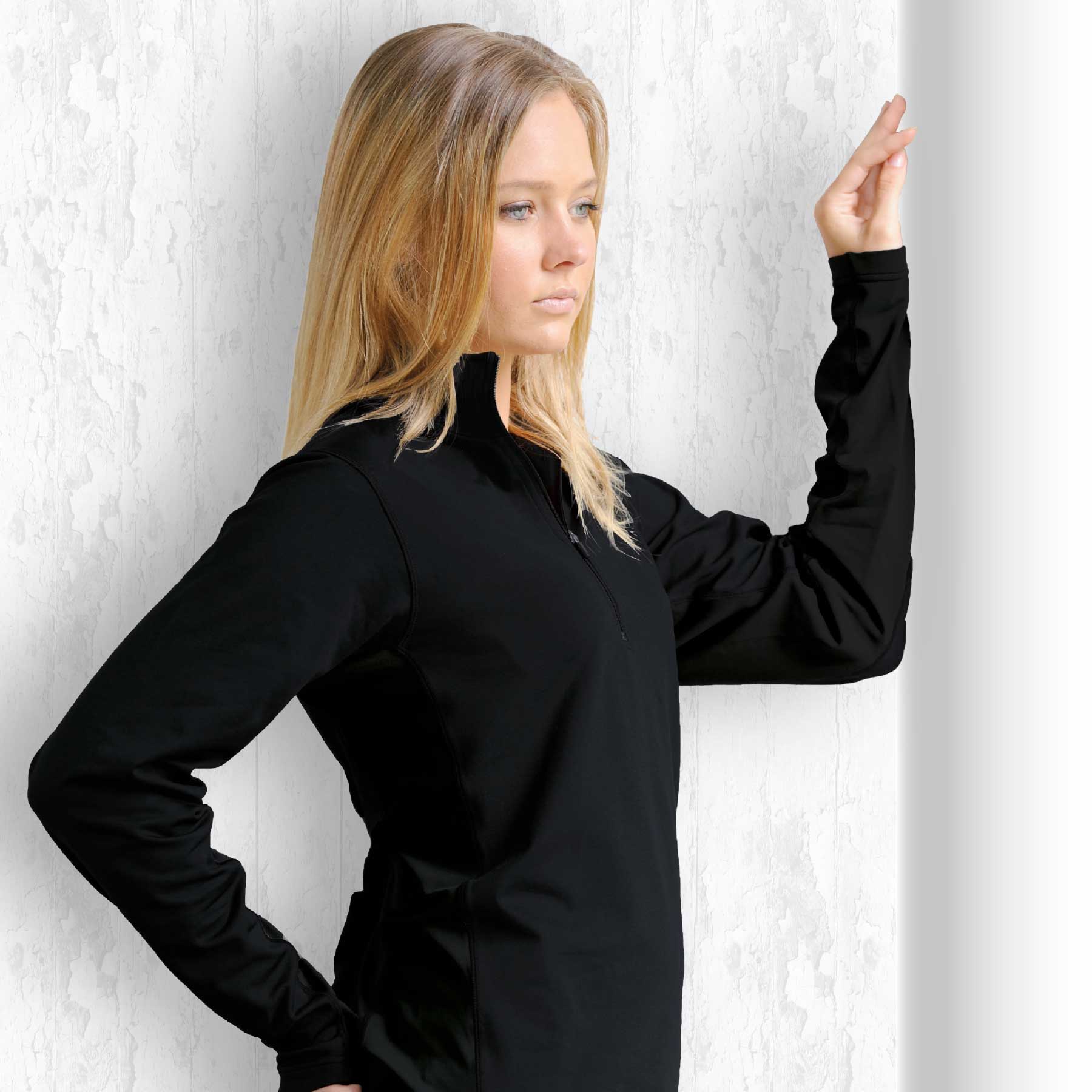 A black long-sleeve top with a zip collar displayed against a textured background. Transition Top - Image 1