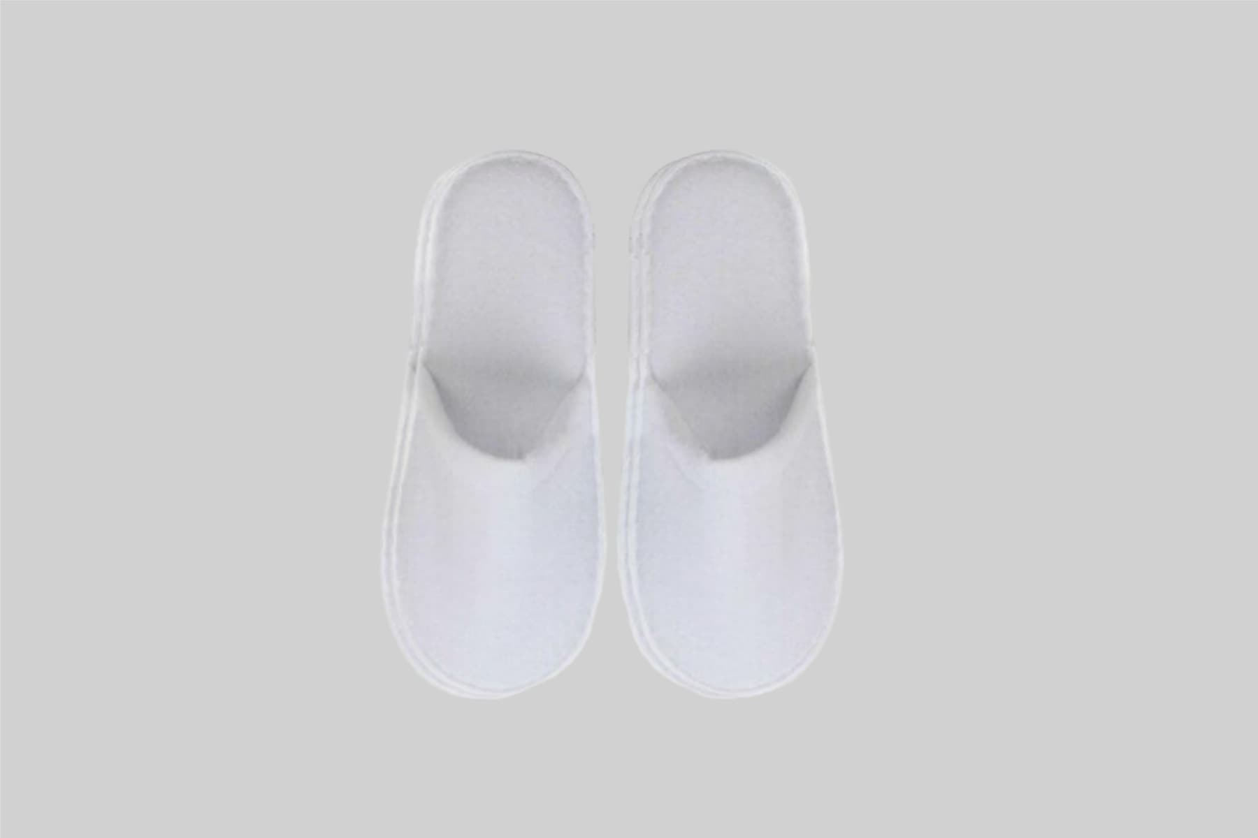 White closed-toe spa bathroom slippers, featuring a simple design and soft fabric. Ideal for a relaxing experience. Spa Bathroom Slippers Closed Toe - Image 1