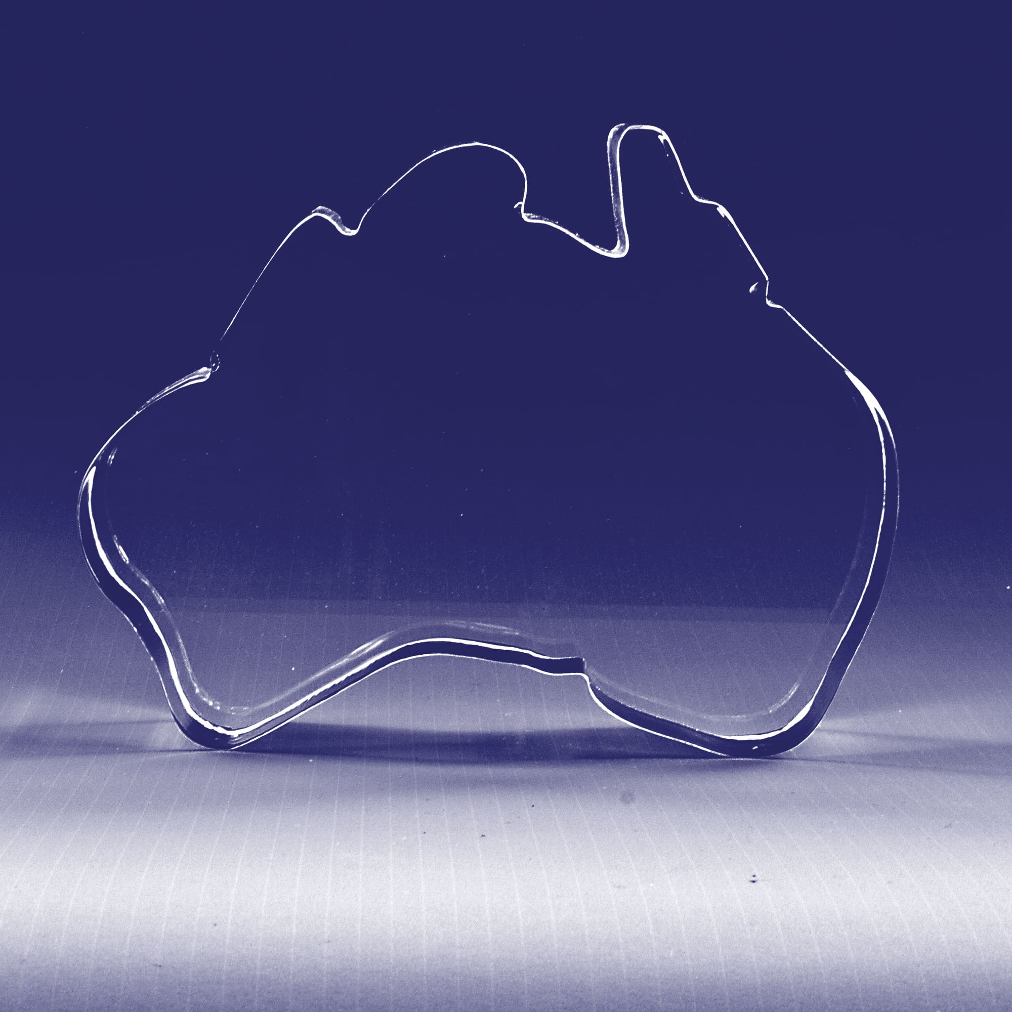 A 3D crystal shaped like Australia, clear with smooth edges, showcasing the country's outline. 3D Crystal Australia Shape (70mm wide) - Image 1