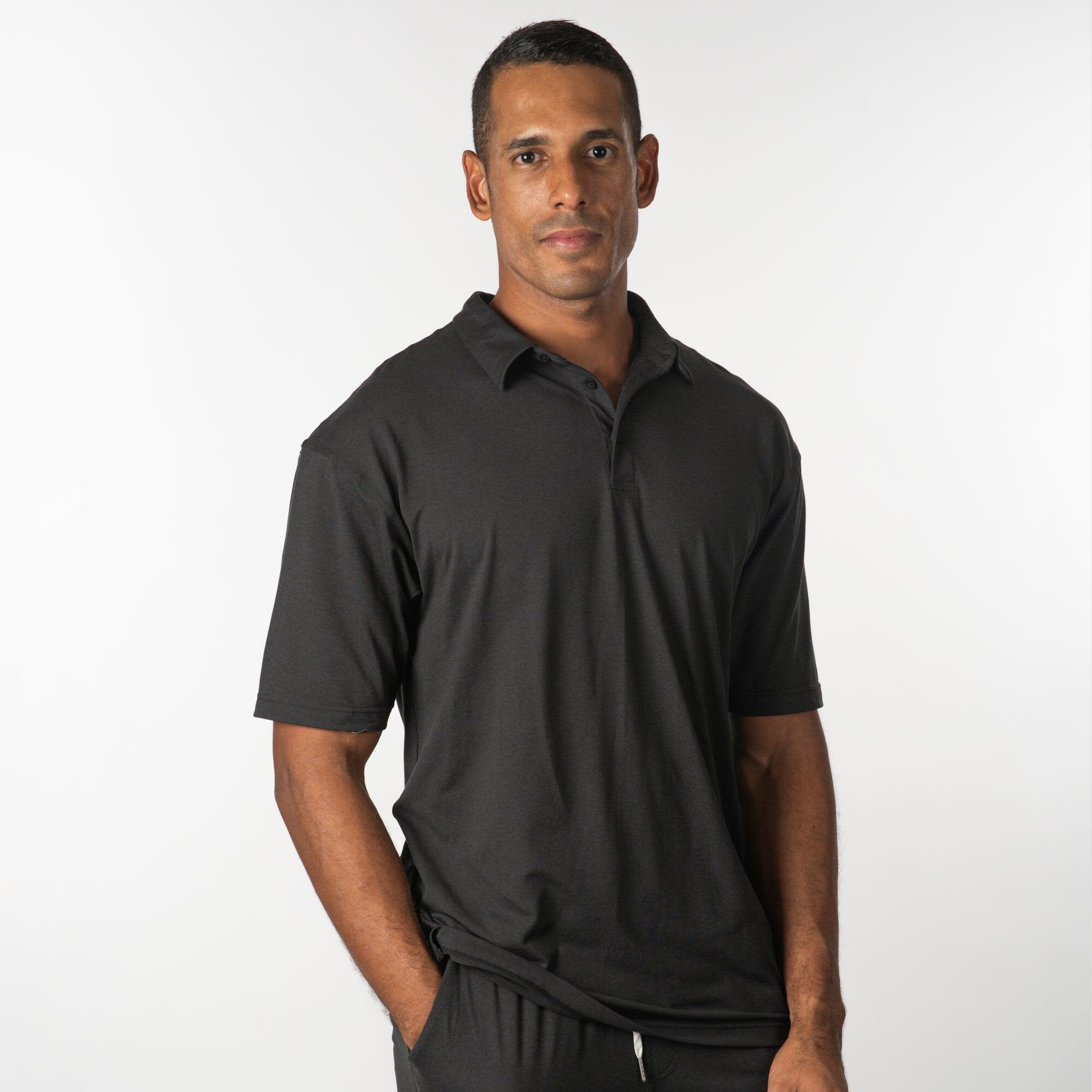 A man wearing a black soft jersey polo shirt, posing against a white background. The shirt has a collar and short sleeves. Soft Jersey Polo - Image 1