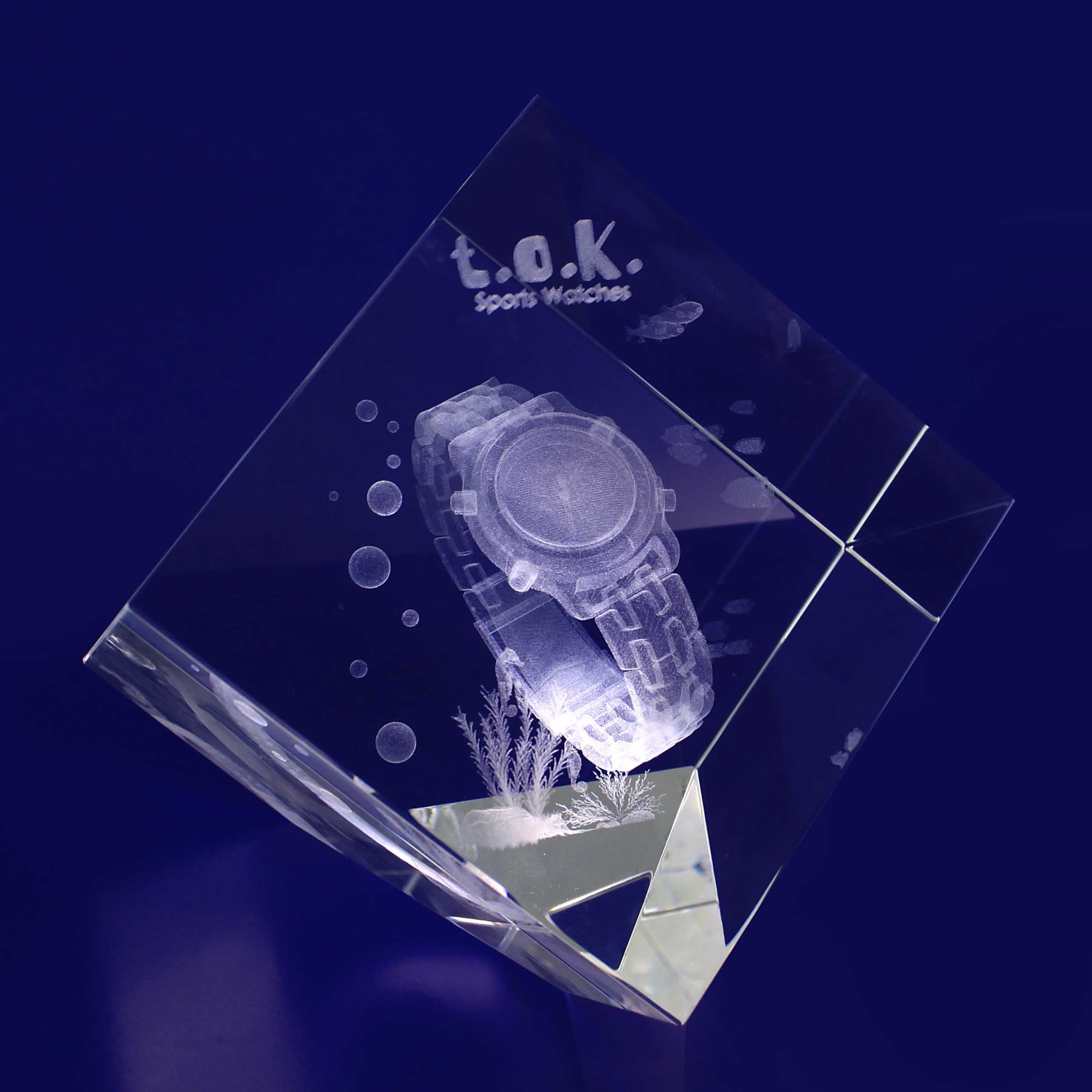 A clear 3D crystal diamond showcasing a detailed optical engraving of a sports watch, with a brand logo and bubbles. 3D Crystal Diamond (100mm) - Image 1