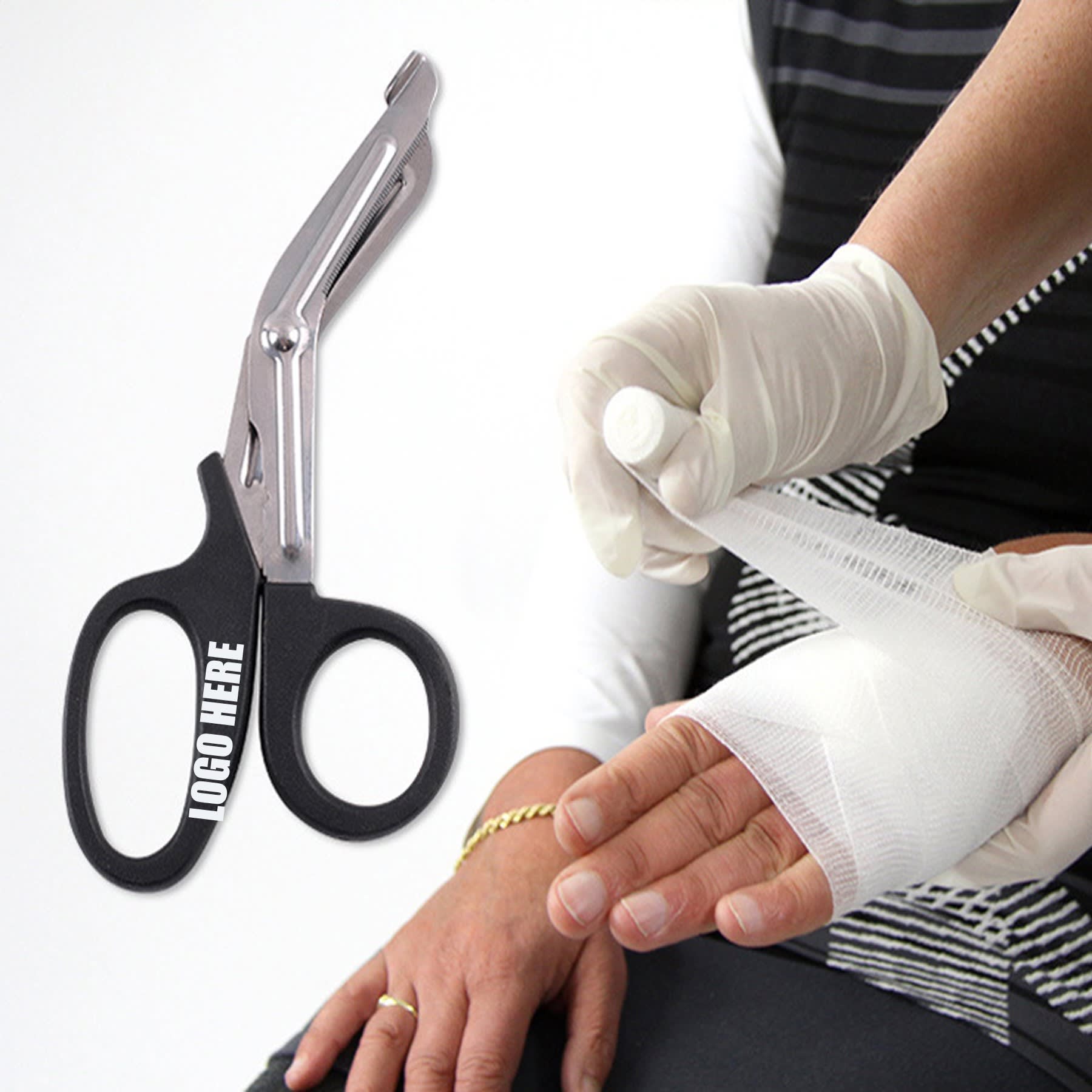 A pair of black bandage scissors with a silver blade, alongside a gloved hand applying a bandage. Bandage Scissor - Image 1