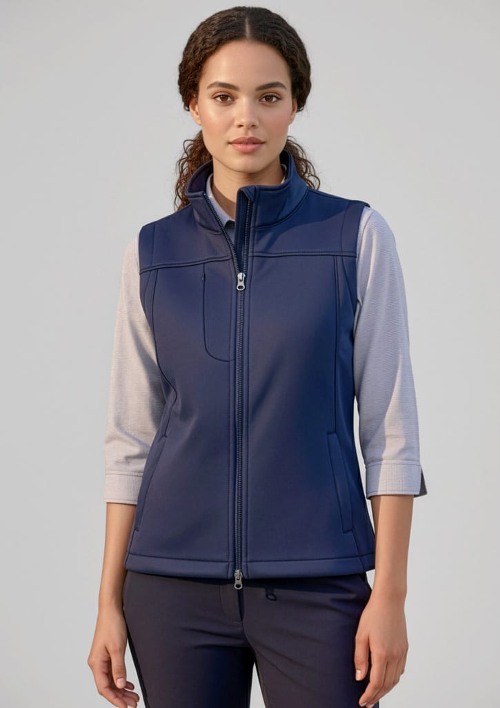 A women's softshell vest in navy blue, featuring a zip front and a collar, paired with a light long-sleeve top. Womens Softshell Vest - Image 1