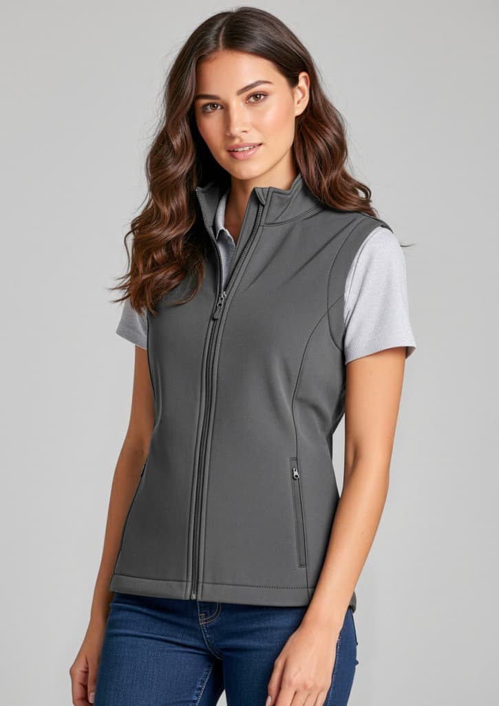 A women's grey vest with a zip front and side pockets, featuring a fitted style and a logo. Womens Apex Vest - Image 1