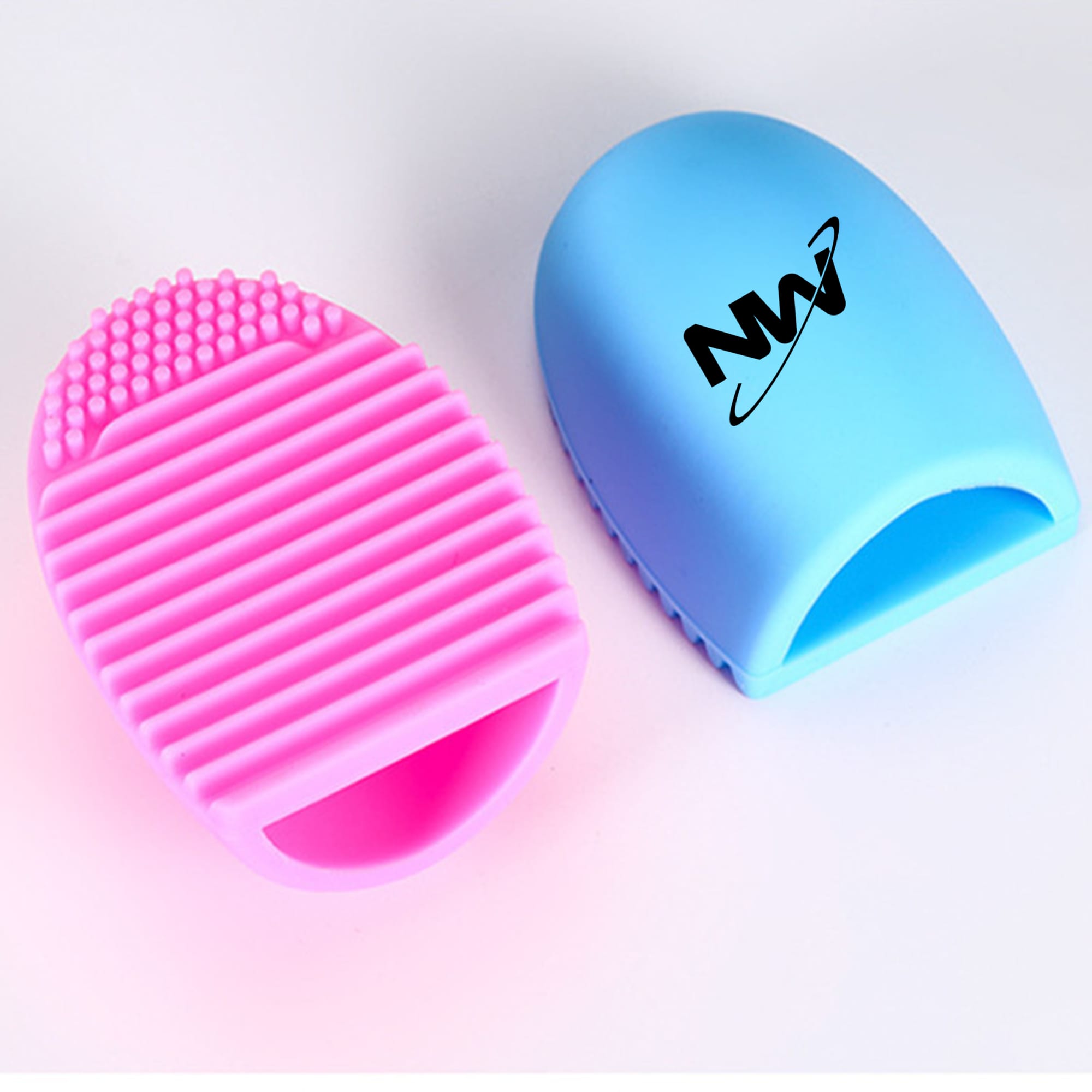 A silicone makeup brush cleaner in pink and blue, featuring text branding on one side and textured surfaces for cleaning. Silicone Makeup Brush Cleaner - Image 1