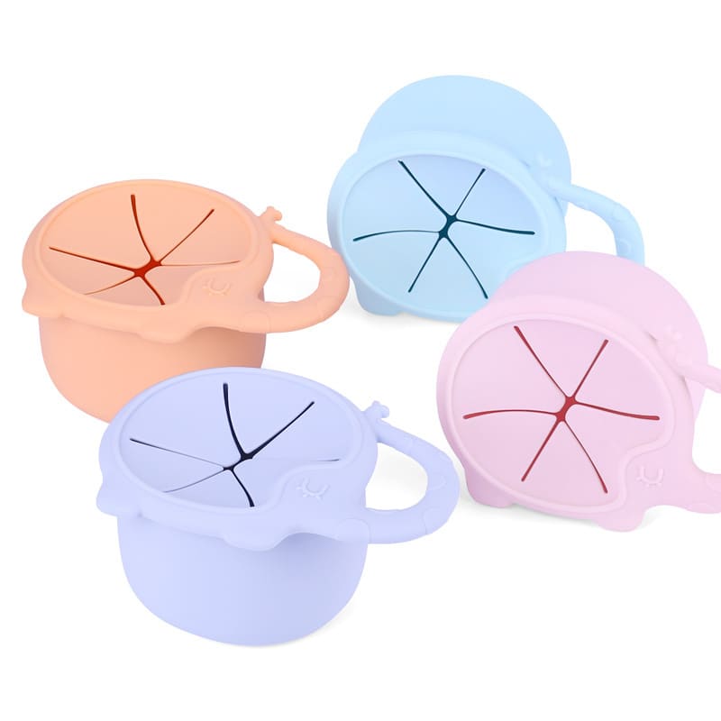 Four silicone elephant-shaped snack catchers in pastel colours: peach, blue, lavender, and pink. Each has a handle and segmented design. Silicone Elephant Snack Catcher - Image 1
