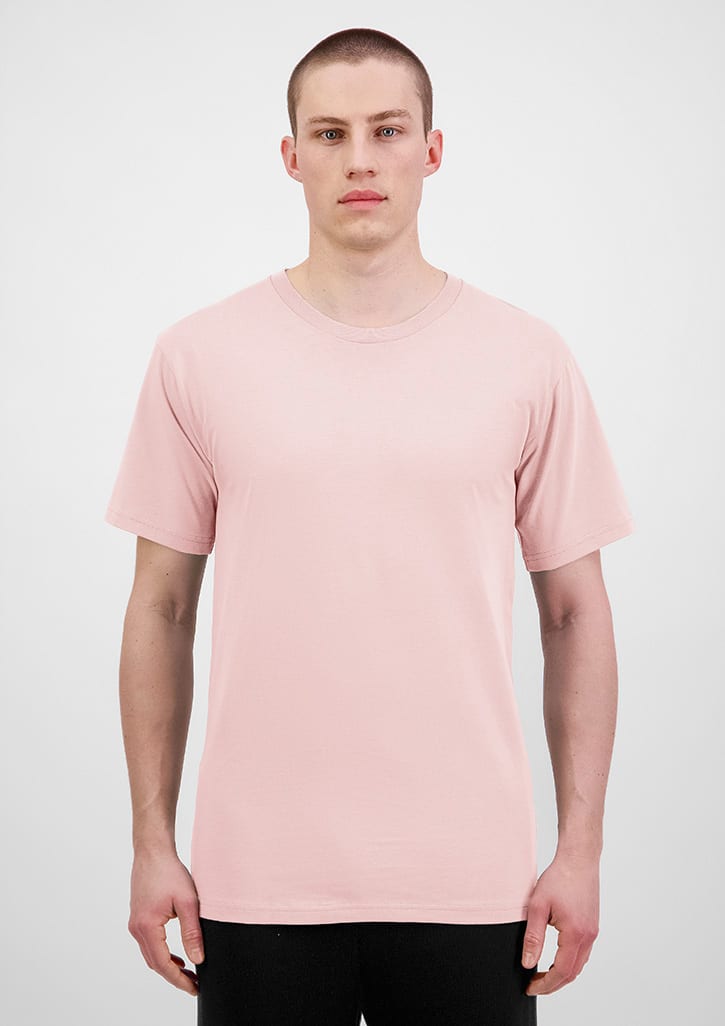 A plain pink short sleeve tee is displayed on a model against a neutral background. The shirt features a logo. Mens Basis Short Sleeve Tee - Image 1