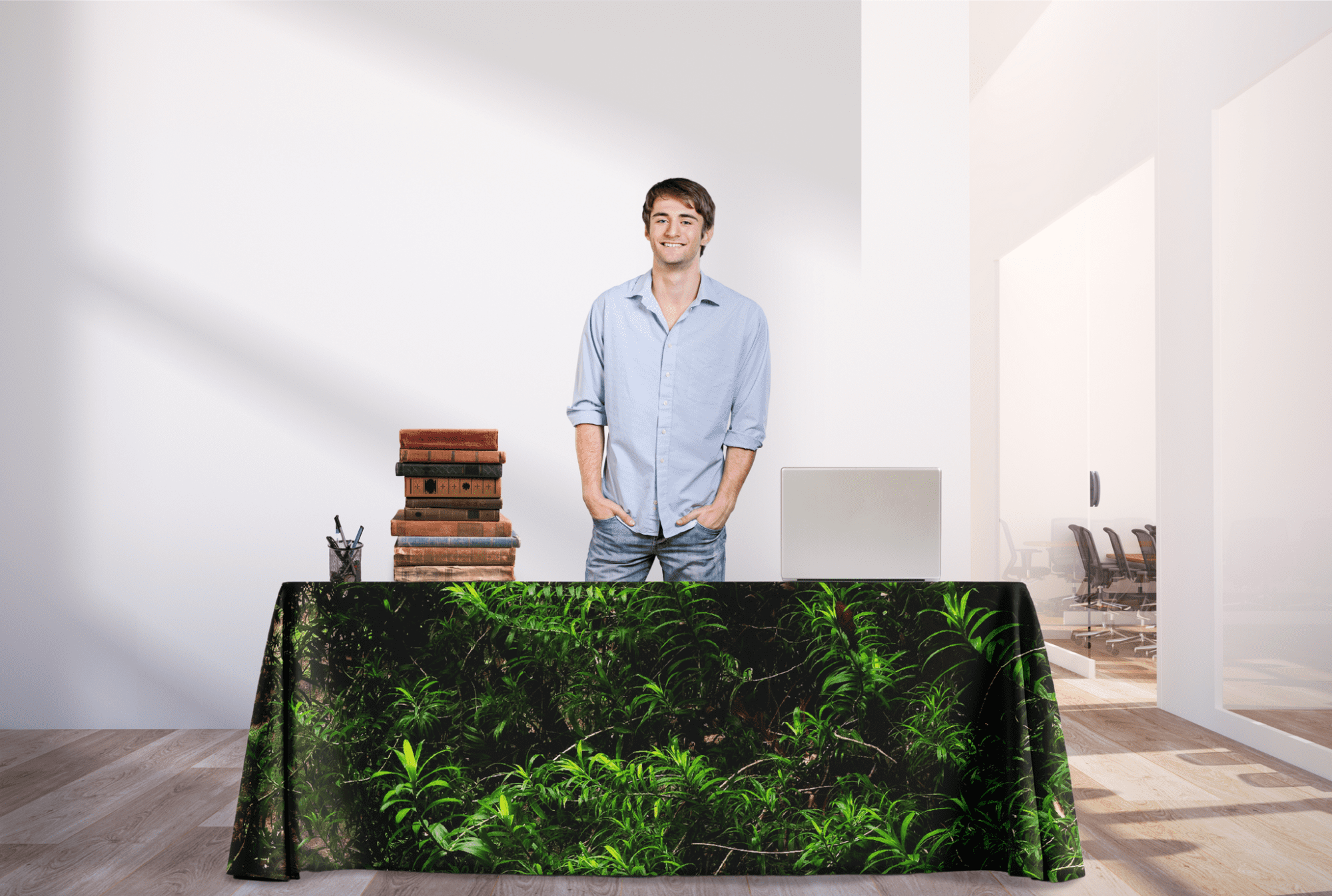 A 6ft rPET table cover in green foliage design, draping over a table with a man standing behind it and a bright interior. rPET Throw Table Cover 6ft (1800mm) - Image 1
