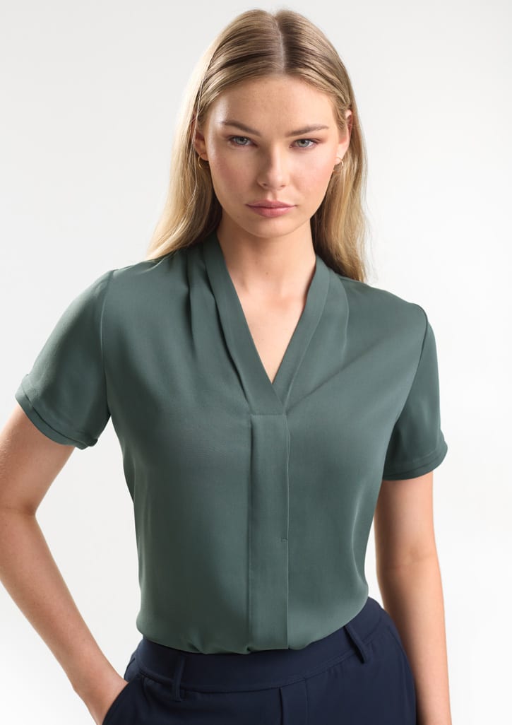 A short-sleeve button-up shirt in a soft green colour, featuring a v-neck design and a subtle front pleat. Womens Madison Short Sleeve Shirt - Image 1