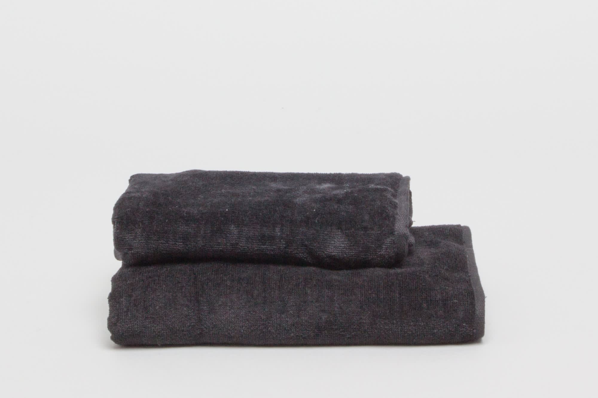 Two black hand towels neatly stacked on a white background. The towels have a soft, textured appearance. Signature Hand Towel 380 gsm Black - Image 1