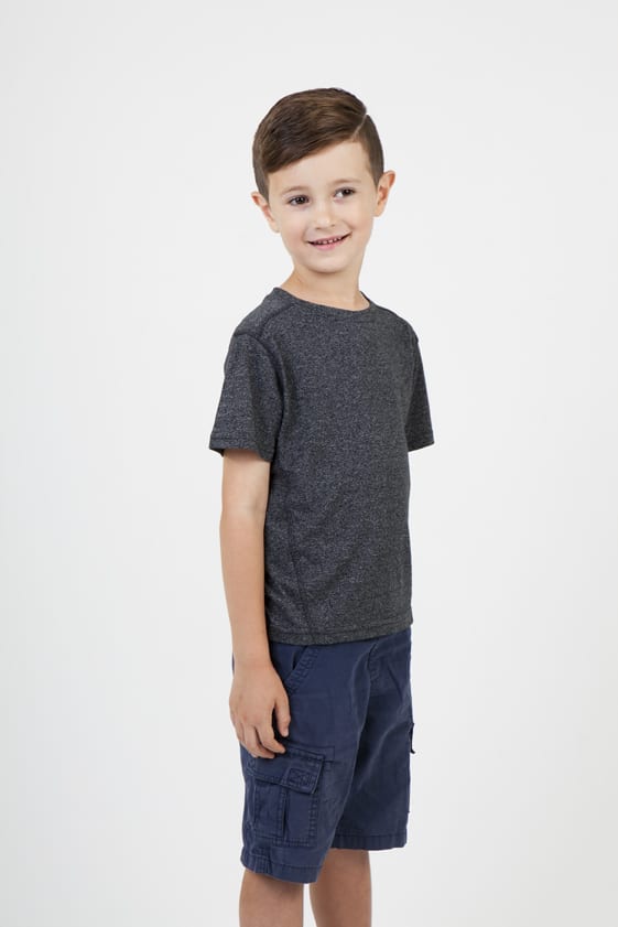 A child models a grey heather t-shirt paired with navy shorts, showcasing a casual style. Kids Heather Tees - Greatness Range - Image 1