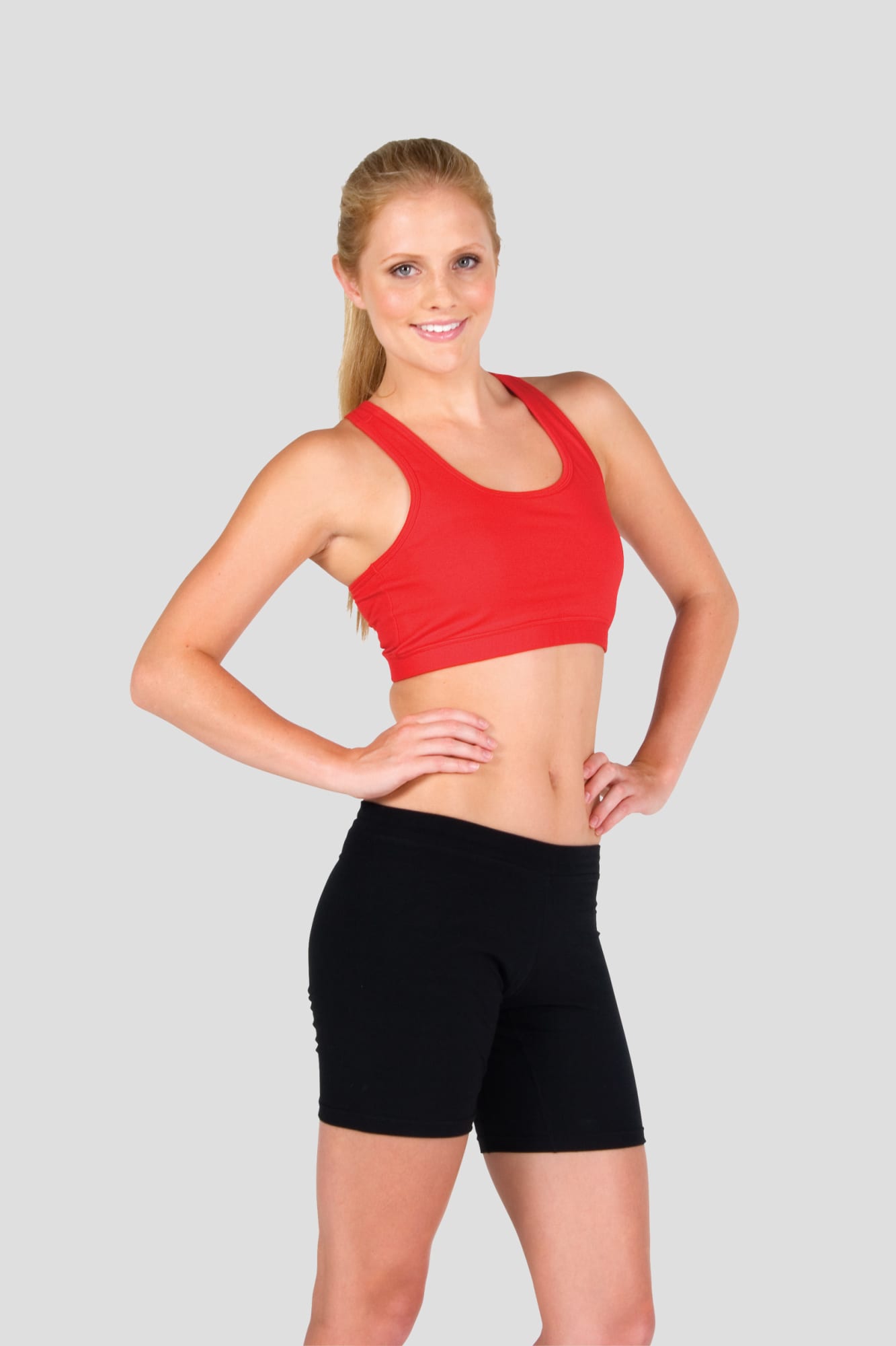 A red crop top with a fitted design, paired with black shorts, showcased on a model against a grey background. Womens Self Brassiere Singlet - Image 1