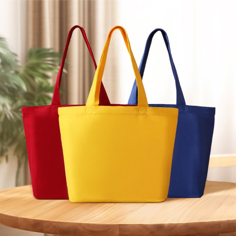 Three tote bags in red, yellow, and blue, featuring handles and a solid colour design. Hawii cotton canvas bag - Image 1