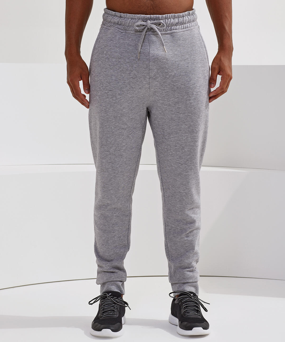 Fitted joggers in light grey, featuring an elastic waistband and a casual fit. The model wears dark footwear. Fitted Joggers - Image 1