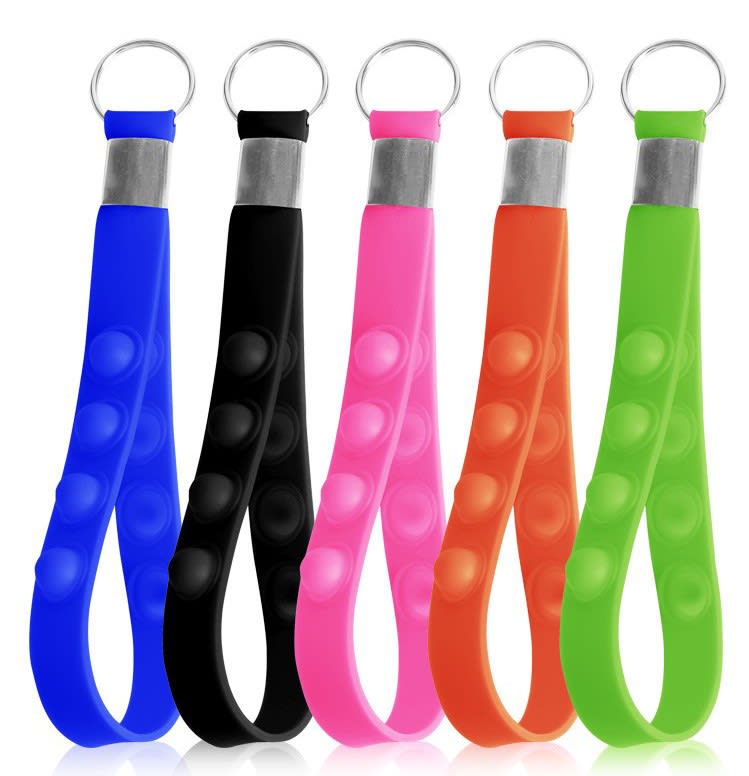 A collection of five push pop stress reliever keychains in blue, black, pink, orange, and green, each with a metal ring. Push Pop Stress Reliever Keychain - Image 1