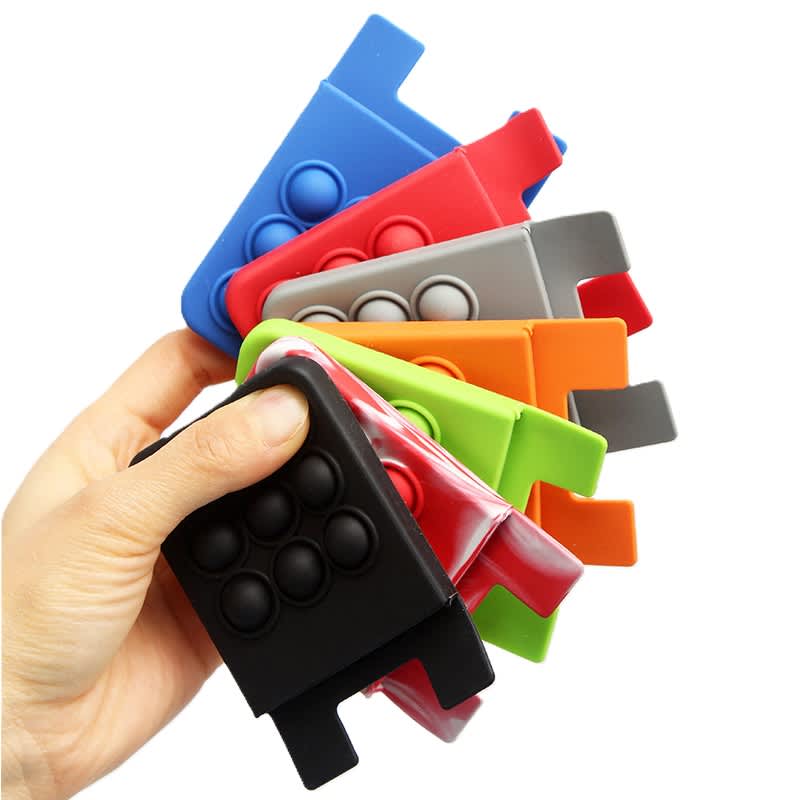 A hand holding a variety of colourful custom push pop phone wallets in red, blue, green, orange, grey, and black. Custom Push Pop Phone Wallet - Image 1