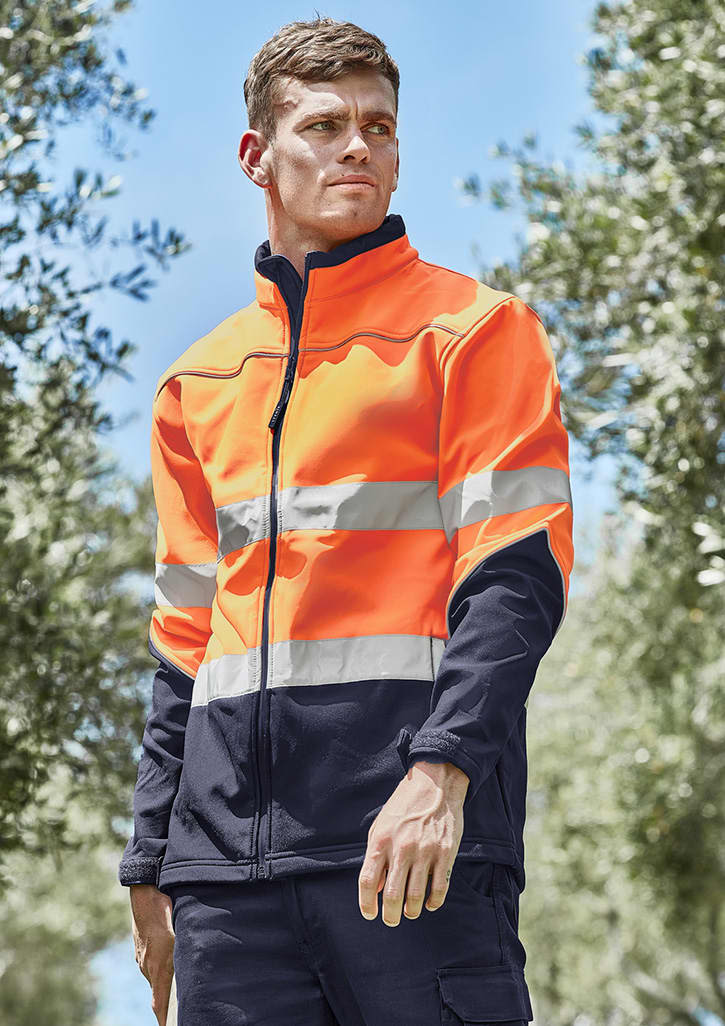 A hi-vis softshell jacket in bright orange and navy, featuring reflective stripes and a zipped front, worn by a model outdoors. Unisex Hi Vis Softshell Jacket - Image 1