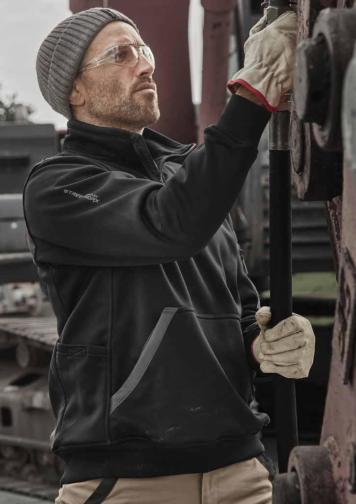 A black water-resistant 1/4 zip pullover worn by a person with safety glasses and gloves, working with machinery. Unisex Streetworx Water Resistant 1/4 Zip Pullover - Image 1