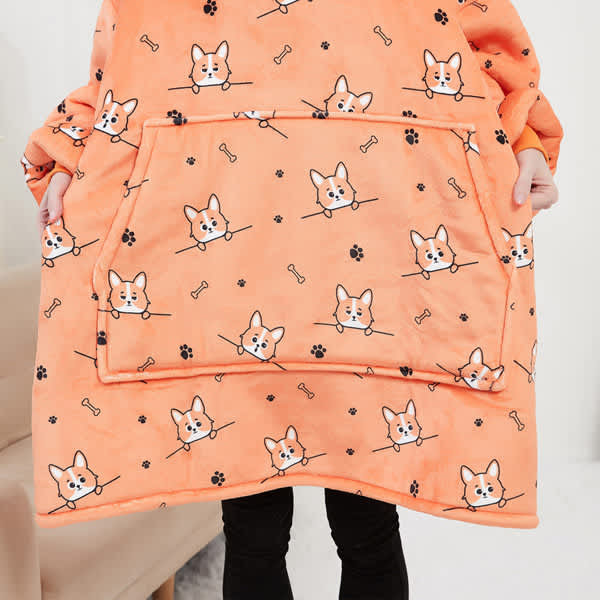 An orange flannel hoodie blanket featuring a cute corgi and bone pattern, with a large front pocket. Women Flannel Hoodie Blanket - Image 1