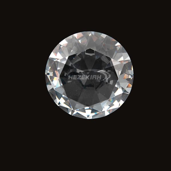 A diamond-shaped paperweight featuring a clear, faceted surface, with a logo in the centre. Custom Diamond Shaped Paperweight - Image 1