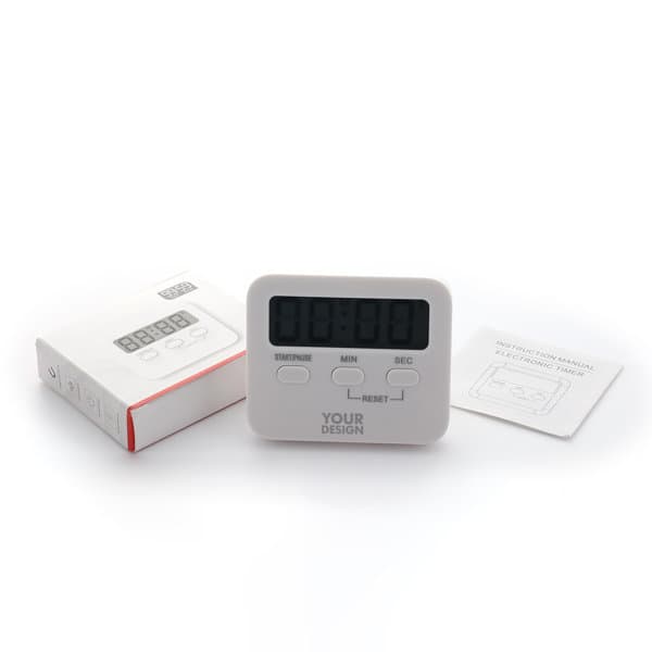 A white digital kitchen timer with a display and buttons, positioned beside its packaging and instruction manual. Digital Kitchen Timer - Image 1