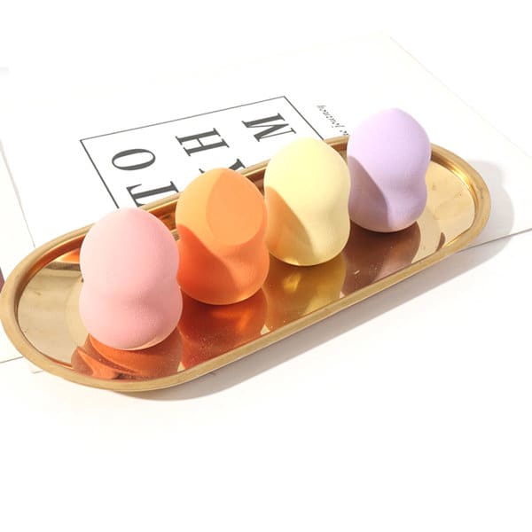 A tray holds four gourd-shaped makeup sponges in pink, orange, yellow, and purple. The tray is gold in colour. Gourd Makeup Sponge With Lanyard Eggshell - Image 1